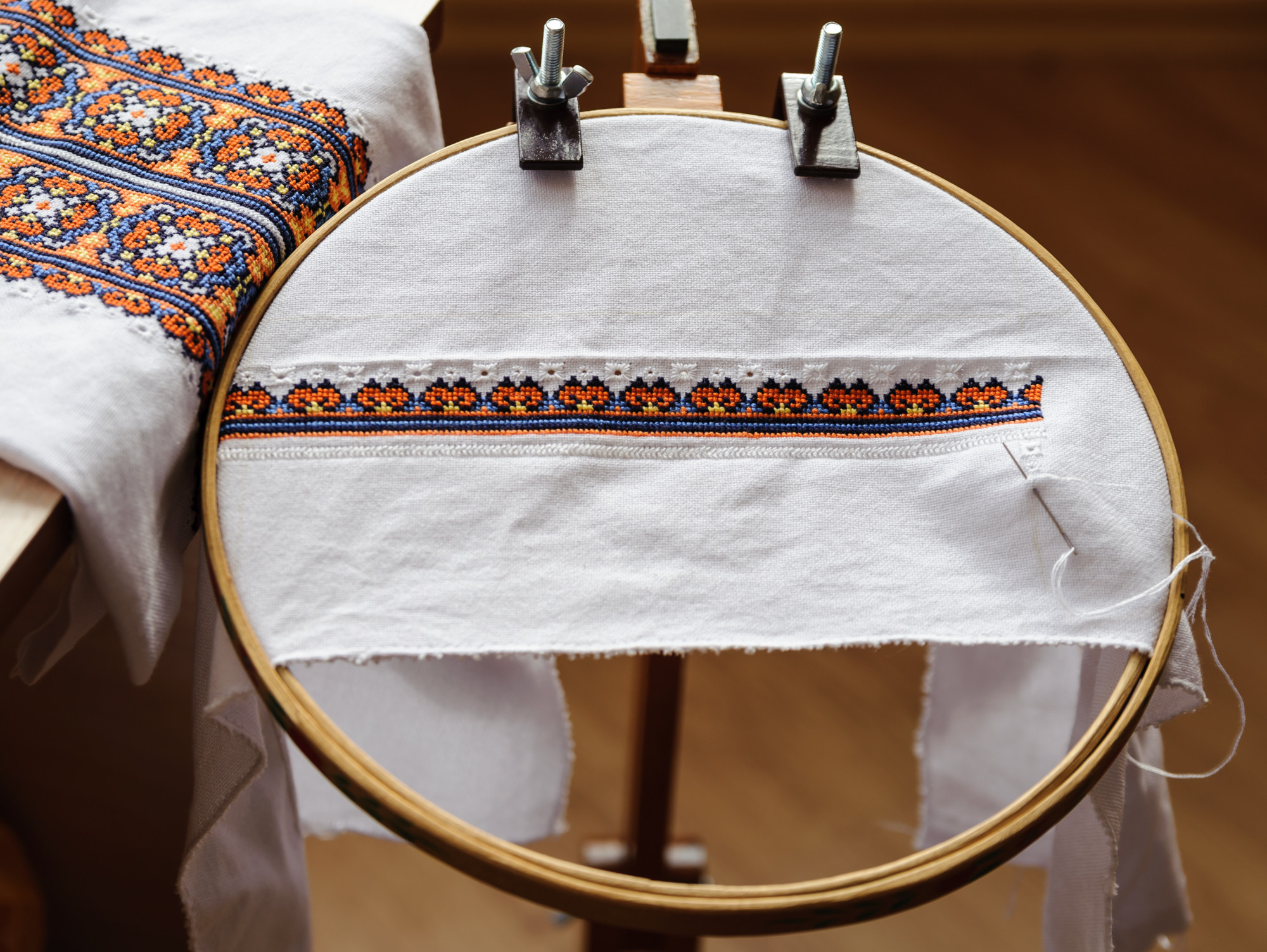 Large embroidered banner draped on wooden table